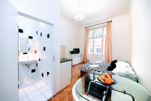 a white living room with a tub and a kitchen at Black & White Flat for 2 / Peaceful / Jewish Quarter in Prague