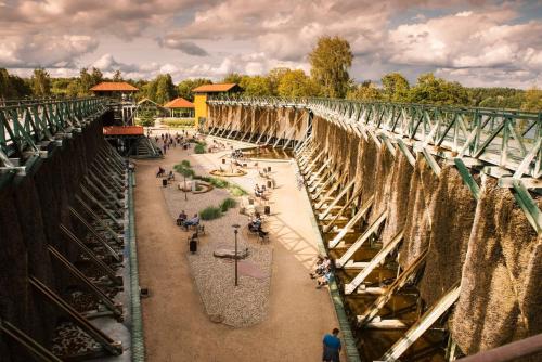 a bridge with people walking around a park at Osada Jaćwingów in Gołdap