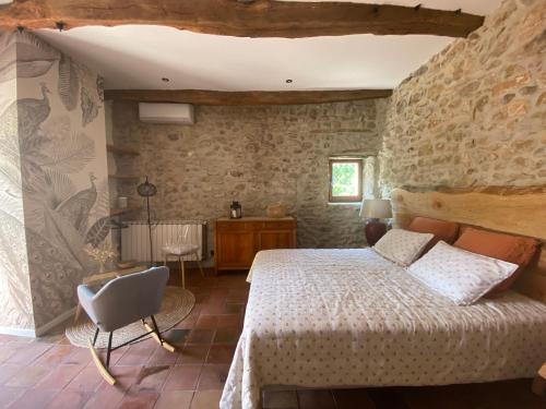une chambre avec un lit dans un mur de pierre dans l'établissement Gîte du mas du Belbuis, à Rochegude