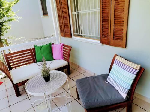 a porch with two chairs and a table and a couch at Country House in Sozopoli