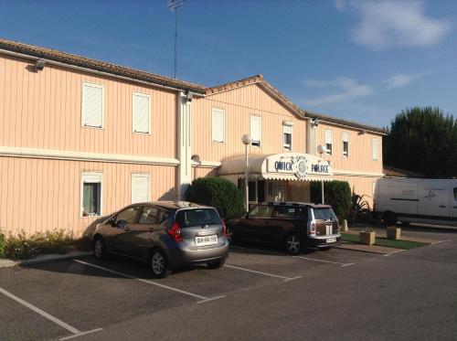 two cars parked in a parking lot in front of a building at Quick Palace St Jean De Vedas - A709 in Saint-Jean-de-Védas