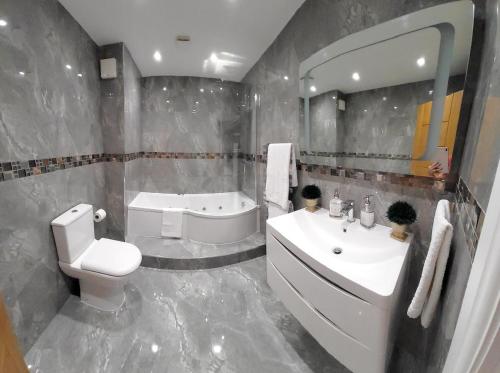 a bathroom with a sink and a toilet and a tub at Home away from home in London