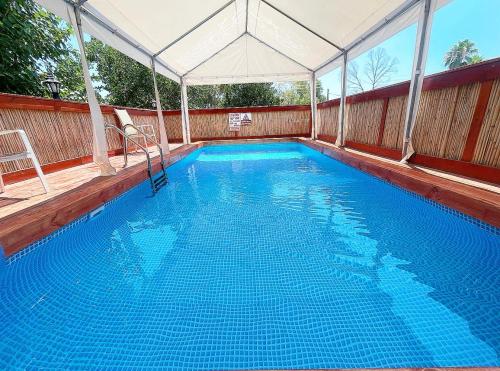 a large blue swimming pool with a marquee at פינה במעיין in Mishmār Hāyardin