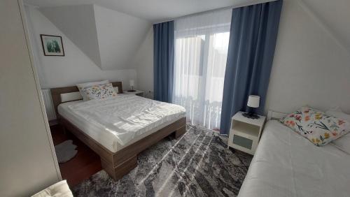 Habitación pequeña con 2 camas y ventana en Roki Bled, en Bled
