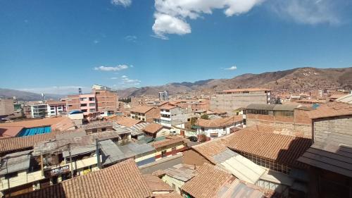 a view of a city with buildings and mountains at TahuanWasi Apartments in Cusco