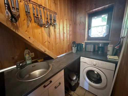 uma cozinha com um lavatório e uma máquina de lavar roupa em Modernes Top Apartment mitten im Bayerischen Wald + WLAN kostenfrei em Schöfweg