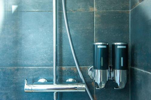 a bathroom with two soap dispensers on a wall at Appartement Proche Gare Routière in Fougères