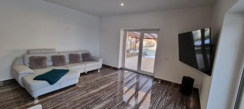 ein Wohnzimmer mit Couch und Flachbildfernseher in der Unterkunft HŐS Vendégház MISKOLC -önálló vendégház, mely csak az Önöké in Miskolc