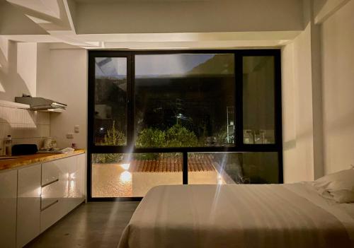 een slaapkamer met een bed en een groot raam bij Zerenna Sacred Valley Boutique Hotel in Coya