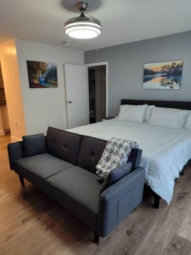 加兹登Serene Studio Apt in Gadsden AL的带一张大床和一张沙发的卧室