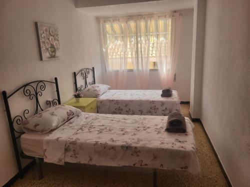 a bedroom with two beds and a window at Virgen de los desamparados in Puerto de Sagunto