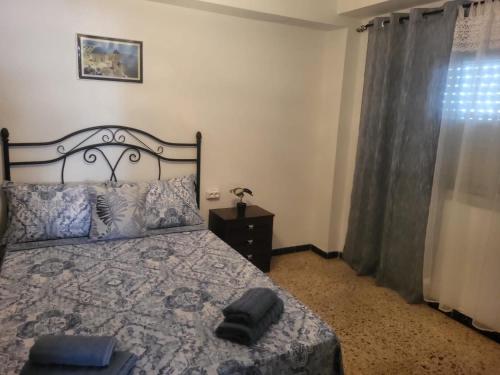 Un dormitorio con una cama con un sombrero negro. en Virgen de los desamparados, en Puerto Sagunto