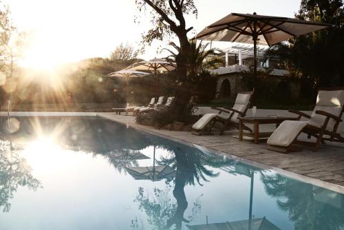 una piscina con sillas y sombrillas, una mesa y una mesa en Lanthia Resort, en Santa Maria Navarrese