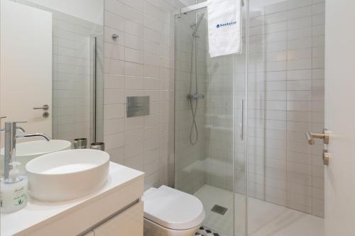 y baño blanco con lavabo y ducha. en Refreshing Cozy Flat - Garden & Terrace, en Oporto