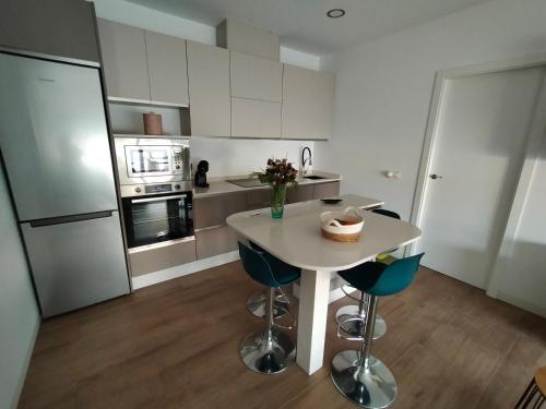 a kitchen with a table and chairs and a refrigerator at Ático los cocones in Carboneras