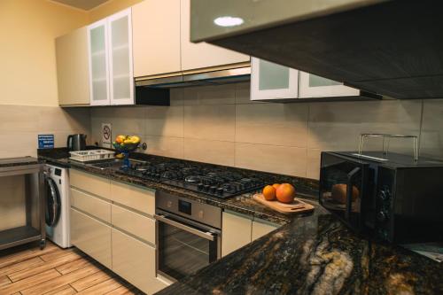 a kitchen with a stove and a counter with oranges on it at Morelowa przystań in Gdańsk