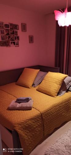 a bedroom with a bed with yellow sheets and pillows at chambre et salle de bain privée chez l habitant Nina in Champigny-sur-Marne