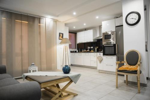 a kitchen and living room with a couch and a table at chambre et salle de bain privée chez l habitant Nina in Champigny-sur-Marne