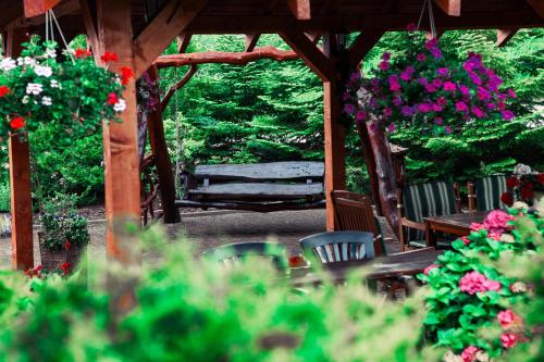 a wooden gazebo with a bench and some flowers at Morelowa przystań in Gdańsk
