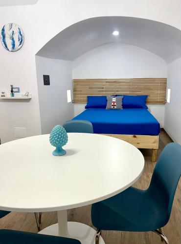 Pokój z łóżkiem oraz białym stołem i krzesłami w obiekcie Archi In Centro Apartment w mieście Vieste