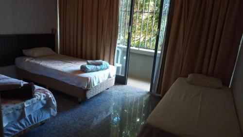 a room with two beds and a window at Beiruth Hotel in Brasília