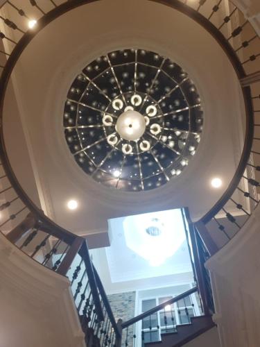 a spiral staircase with a ceiling with a chandelier at Royal Feather in Tirunelveli East