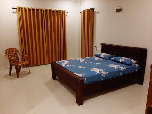 - une chambre avec un lit, une chaise et des rideaux dans l'établissement Royal Feather, à Tirunelveli East