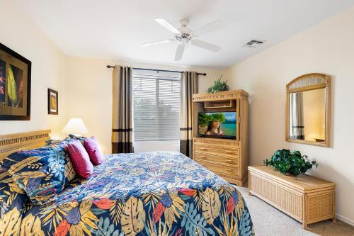 um quarto com uma cama e uma televisão de ecrã plano em Fairway Villas Waikoloa B21 em Waikoloa