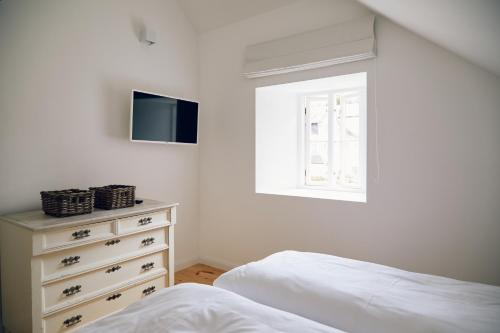 a bedroom with a bed and a dresser with a television at Försterei in Barkelsby