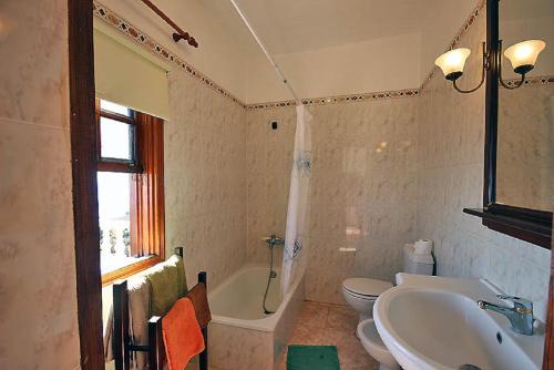 a bathroom with a tub and a sink and a toilet at Las Palmeras B in Arecida