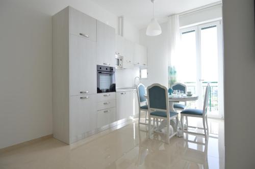 uma cozinha com armários brancos e uma mesa com cadeiras em Balcone in Valle d'Itria em Martina Franca