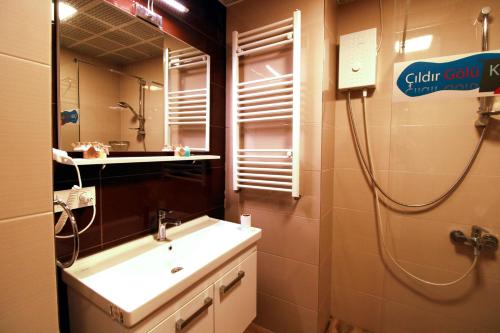 a bathroom with a sink and a mirror at Lake Cildir Lodge in Çıldır