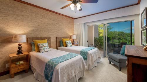 a bedroom with two beds and a balcony at Mauna Lani Villages 407 in Waikoloa