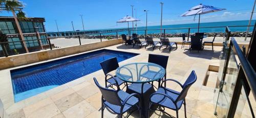 a patio with a table and chairs next to a pool at Flat na praia de iracema,vista mar 606 in Fortaleza