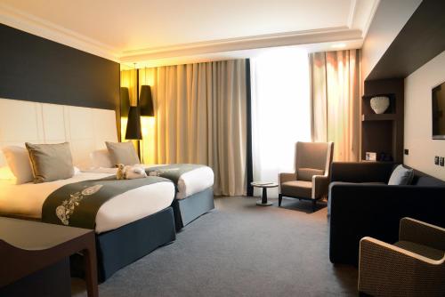 a hotel room with two beds and a chair at InterContinental Marseille - Hotel Dieu by IHG in Marseille
