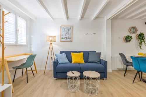 un salon avec un canapé bleu et des chaises dans l'établissement Appartement Frêne - Welkeys, à Lyon