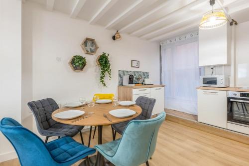 une cuisine et une salle à manger avec une table et des chaises en bois dans l'établissement Appartement Frêne - Welkeys, à Lyon