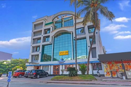 a large building with cars parked in front of it at Indrapuri Rajadhani in Trivandrum