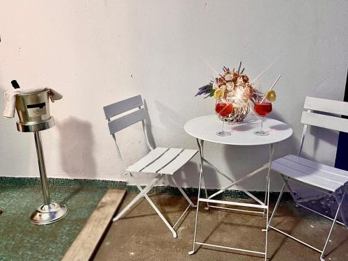 a table with a vase of flowers and two chairs at Villa Eden in Domusnovas