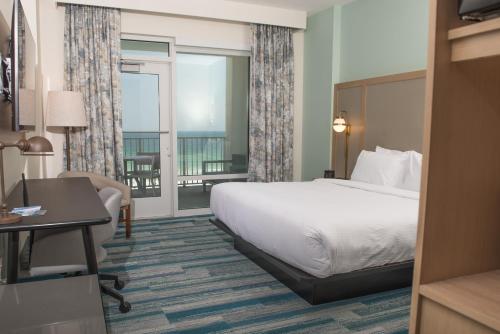 a hotel room with a bed and a balcony at Fairfield by Marriott Inn & Suites Pensacola Beach in Pensacola Beach