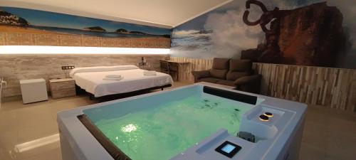 een kamer met een bad met een bed en een slaapkamer bij Pensión Astigarraga in Astigarraga