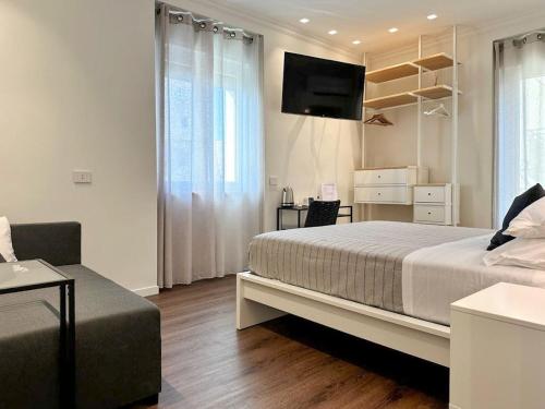 um quarto com uma cama, uma televisão e um sofá em Iblu Rooms em Termoli