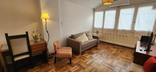 uma sala de estar com um sofá e uma cadeira em Ambar apartamento em Mar del Plata