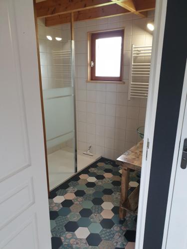 a bathroom with a shower and a tiled floor at LE CHALET in Saint-Pierre-dʼArthéglise