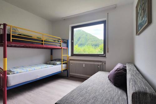 a bedroom with two bunk beds and a window at Familien-Ferienwohnung Lichtenstein (BW) in Lichtenstein