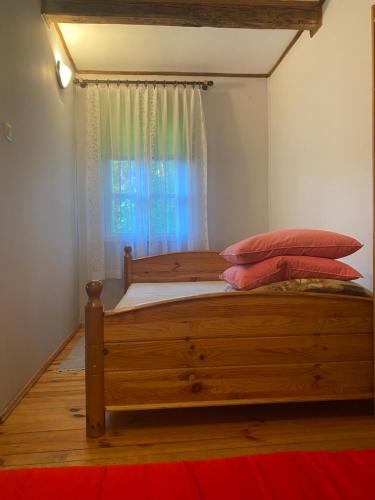 a bedroom with a wooden bed with a window at AGRO-CHATKA in Myszyniec
