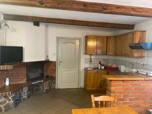 a kitchen with wooden cabinets and a brick fireplace at AGRO-CHATKA in Myszyniec