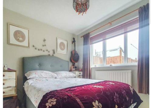 a bedroom with a large bed and a window at Detached Country Bungalow in Wroughton