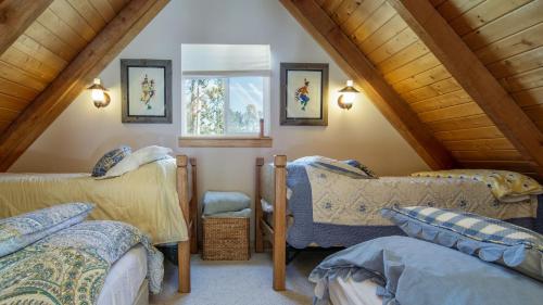 a attic room with two beds and a window at Two-Bedroom Cabin in Frisco in Frisco