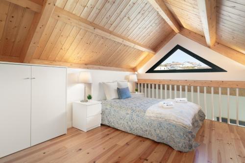 a bedroom with a bed and a wooden ceiling at Host Wise - Lovely & Cozy Duplex Flat in Porto